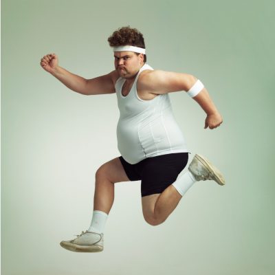 Sportlicher Mann mit Übergewicht zeigt, dass die ausgewogene Ernährung schwer einzuhalten ist