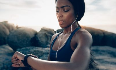 Intervallfasten Mythen: Frau prüft ihre sportliche Leistung beim Fasten mit Blick auf die Smartwatch