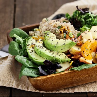 Makronährstoffe für den Sport beim Intervallfasten können aus sowohl Kohlenhydraten, Fetten, als auch Proteinen bestehen, wie hier aufgeführt durch Avocado, Salat, Mandarinen und Quinoa